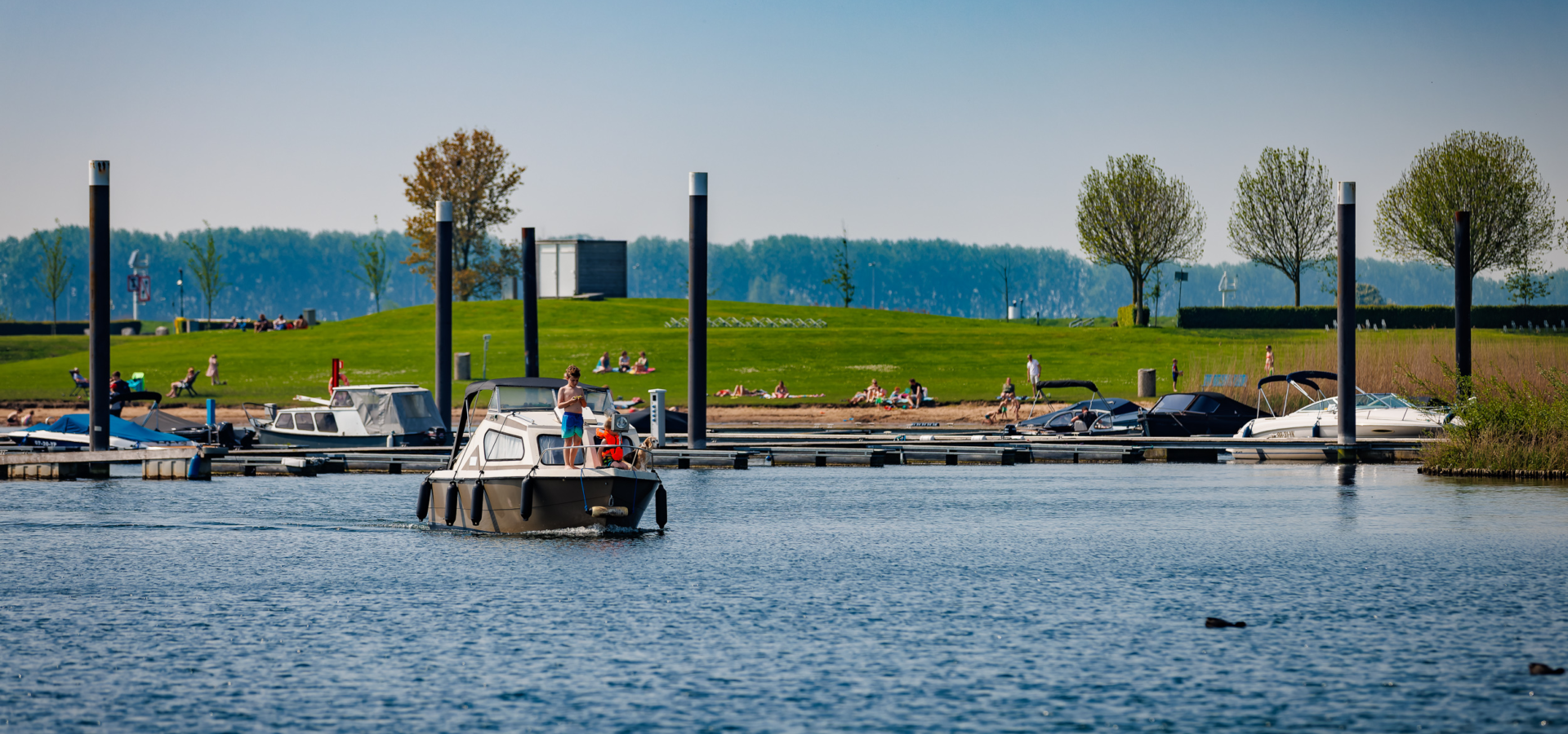 Een boot vaart uit Jachthaven Eiland van Maurik