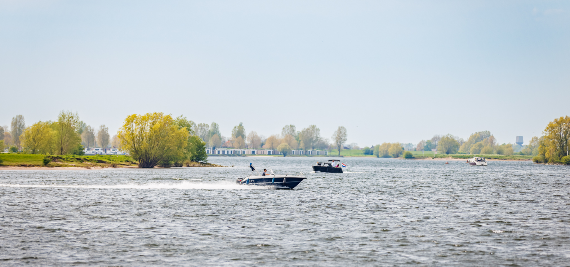 Boot aan het varen bij de haven aan de Nederrijn