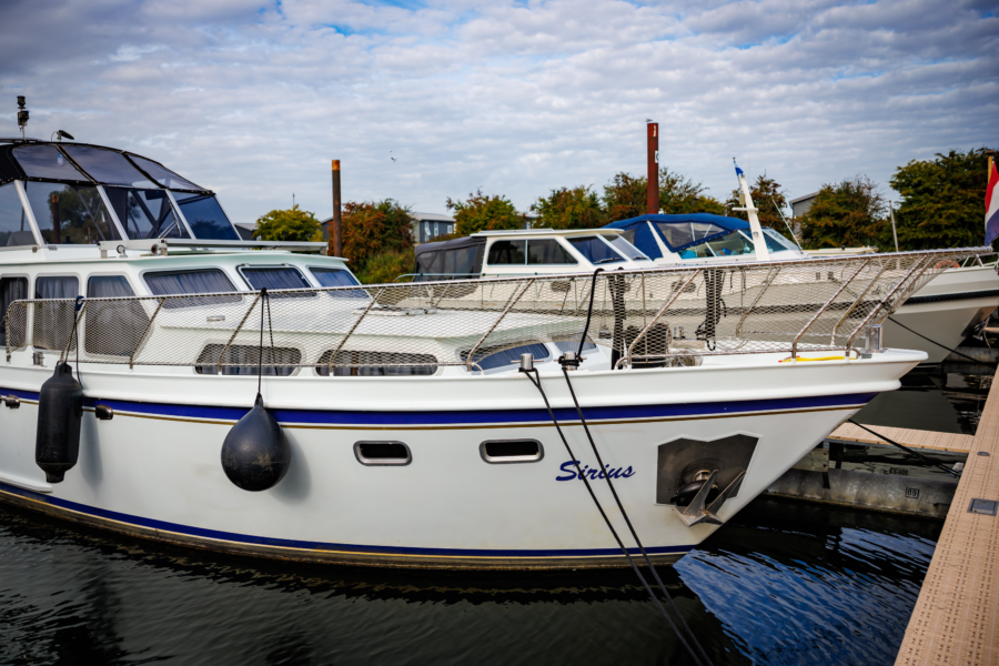 Boot die ligt in een havenplek bij de Nederrijn
