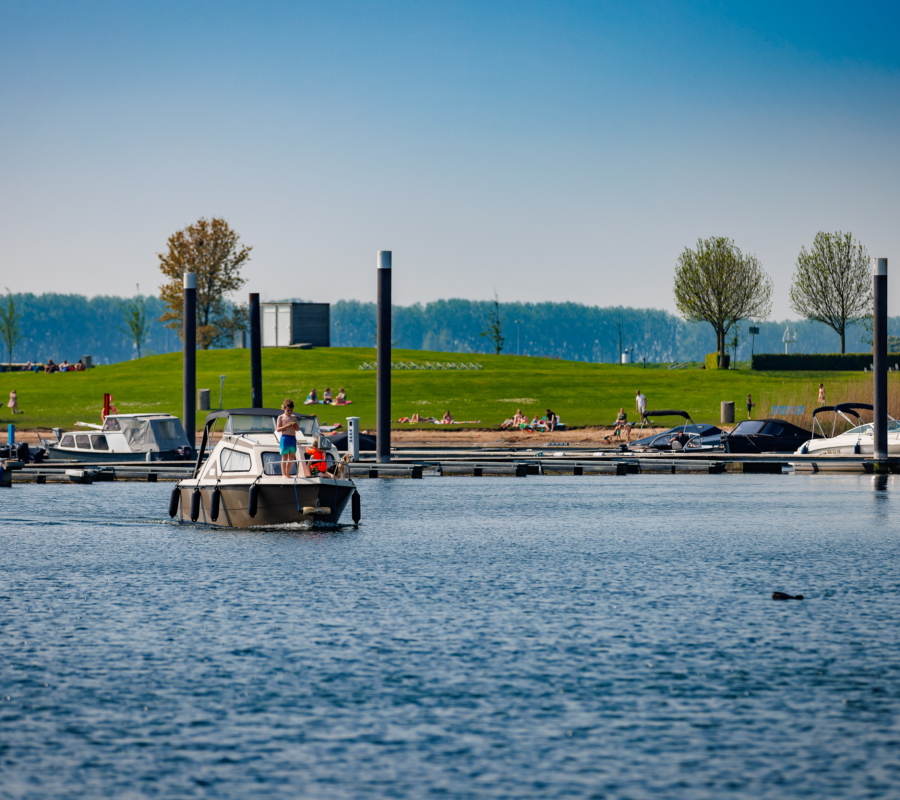 Een boot vaart uit Jachthaven Eiland van Maurik